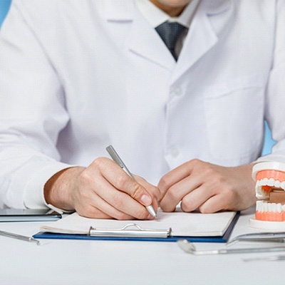 Dentist making notes about patient’s candidacy for All-on-4 treatment