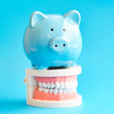 Piggy bank atop model teeth