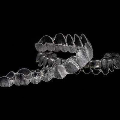 Two clear aligners on black background