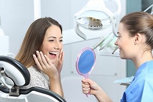 Cosmetic dentist showing patient her new smile