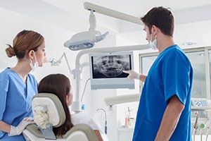 implant dentist showing a patient their dental X-rays